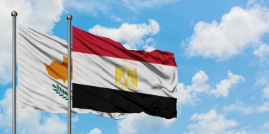 Kıbrıs ve Mısır bayrağı birlikte beyaz bulutlu mavi gökyüzüne karşı rüzgarda sallayarak. Diplomasi kavramı, uluslararası ilişkiler.