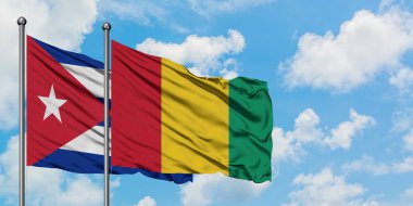 Küba ve Gine bayrağı birlikte beyaz bulutlu mavi gökyüzüne karşı rüzgarda sallayarak. Diplomasi kavramı, uluslararası ilişkiler.