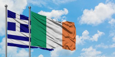 Yunanistan ve İrlanda bayrağı birlikte beyaz bulutlu mavi gökyüzüne karşı rüzgarda sallayarak. Diplomasi kavramı, uluslararası ilişkiler.