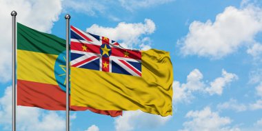 Etiyopya ve Niue bayrağı birlikte beyaz bulutlu mavi gökyüzüne karşı rüzgarda sallayarak. Diplomasi kavramı, uluslararası ilişkiler.