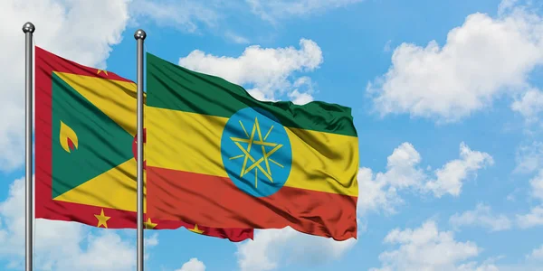 一緒に白い曇り青い空に対して風に手を振るグレナダとエチオピアの旗。外交概念、国際関係. — ストック写真