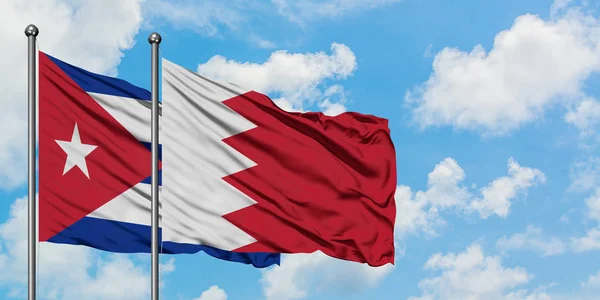 Kubánská a Bahrašská vlajka mávali větrem proti bíle zatažené modré obloze. Diplomacie, mezinárodní vztahy. — Stock fotografie