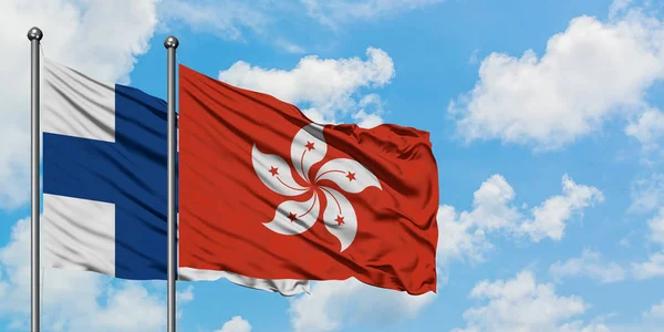 Bandera de Finlandia y Hong Kong ondeando en el viento contra el cielo azul nublado blanco juntos. Concepto diplomático, relaciones internacionales . —  Fotos de Stock