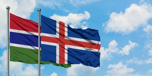 Bandera de Gambia e Islandia ondeando en el viento contra el cielo azul nublado blanco juntos. Concepto diplomático, relaciones internacionales . — Foto de Stock