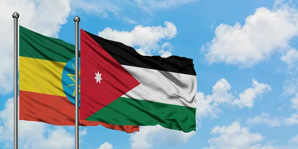 Bandera de Etiopía y Jordania ondeando en el viento contra el cielo azul nublado blanco juntos. Concepto diplomático, relaciones internacionales . — Foto de Stock