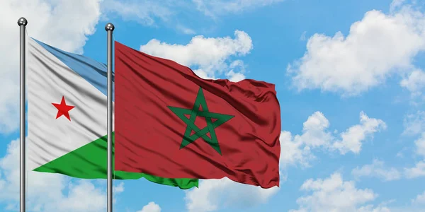 Bandera de Djibouti y Marruecos ondeando en el viento contra el cielo azul nublado blanco juntos. Concepto diplomático, relaciones internacionales . — Foto de Stock