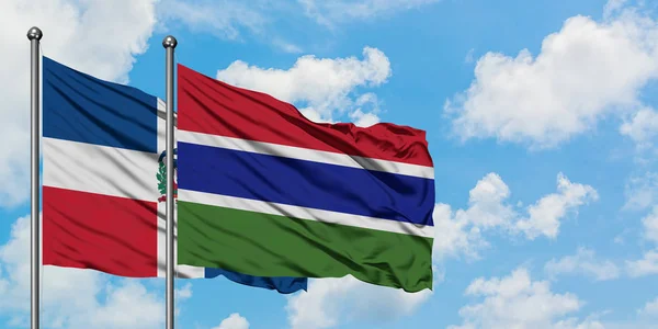 Repubblica Dominicana e Gambia sventolano insieme contro il bianco cielo azzurro nuvoloso. Concetto di diplomazia, relazioni internazionali . — Foto Stock