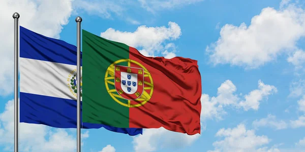 El Salvador ve Portekiz bayrağı birlikte beyaz bulutlu mavi gökyüzüne karşı rüzgarda sallayarak. Diplomasi kavramı, uluslararası ilişkiler. — Stok fotoğraf