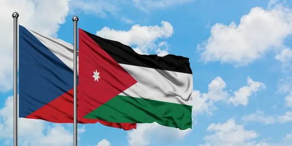 Bandera de República Checa y Jordania ondeando en el viento contra el cielo azul nublado blanco juntos. Concepto diplomático, relaciones internacionales . — Foto de Stock