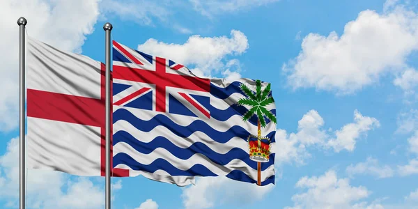 England and British Indian Ocean Territory flag waving in the wind against white cloudy blue sky together. Diplomacy concept, international relations. — Stock Photo, Image