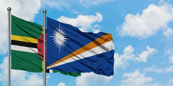 Dominica- und Marshallinseln-Flagge wehen gemeinsam im Wind vor weißem wolkenblauem Himmel. Diplomatie-Konzept, internationale Beziehungen. — Stockfoto