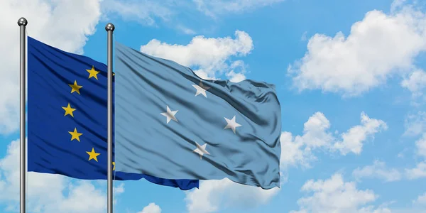 Bandera de la Unión Europea y Micronesia ondeando en el viento contra el cielo azul nublado blanco juntos. Concepto diplomático, relaciones internacionales . — Foto de Stock