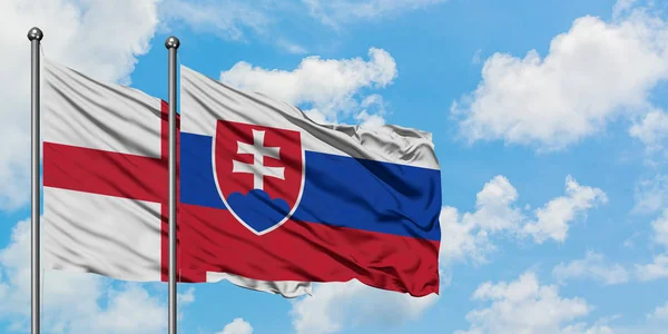 英格兰和斯洛伐克国旗在风中飘扬，与白云蓝天相逢。外交概念、国际关系. — 图库照片
