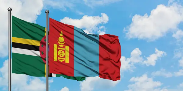 Dominica och Mongoliet flagga vinka i vinden mot vit grumlig blå himmel tillsammans. Diplomatisk koncept, internationella relationer. — Stockfoto