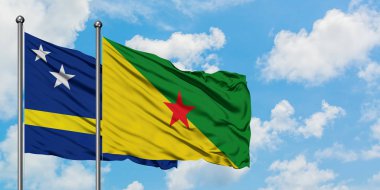 Curacao ve Fransız Guiana bayrağı birlikte beyaz bulutlu mavi gökyüzüne karşı rüzgarda sallayarak. Diplomasi kavramı, uluslararası ilişkiler.