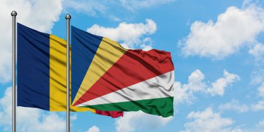 Çad ve Seyşeller bayrağı birlikte beyaz bulutlu mavi gökyüzüne karşı rüzgarda sallayarak. Diplomasi kavramı, uluslararası ilişkiler.