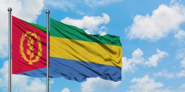 Eritre ve Gabon bayrağı birlikte beyaz bulutlu mavi gökyüzüne karşı rüzgarda sallayarak. Diplomasi kavramı, uluslararası ilişkiler.