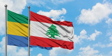 Gabon ve Lübnan bayrağı birlikte beyaz bulutlu mavi gökyüzüne karşı rüzgarda sallayarak. Diplomasi kavramı, uluslararası ilişkiler.