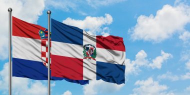 Hırvatistan ve Dominik Cumhuriyeti bayrağı birlikte beyaz bulutlu mavi gökyüzüne karşı rüzgarda sallayarak. Diplomasi kavramı, uluslararası ilişkiler.