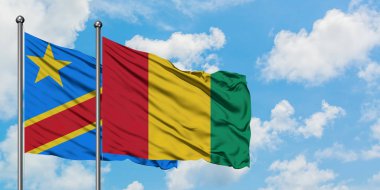 Kongo ve Gine bayrağı birlikte beyaz bulutlu mavi gökyüzüne karşı rüzgarda sallayarak. Diplomasi kavramı, uluslararası ilişkiler.