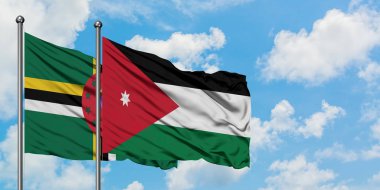 Dominika ve Ürdün bayrağı birlikte beyaz bulutlu mavi gökyüzüne karşı rüzgarda sallayarak. Diplomasi kavramı, uluslararası ilişkiler.