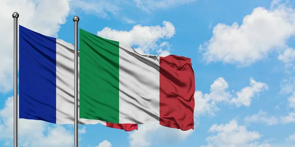 Bandera de Francia e Italia ondeando en el viento contra el cielo azul nublado blanco juntos. Concepto diplomático, relaciones internacionales . — Foto de Stock