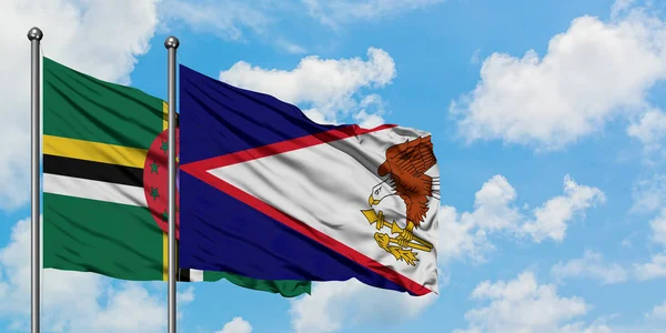 Η σημαία της Δομινίκα και η Αμερικάνικη Σαμόα κουνώντας τον άνεμο εναντίον του λευκού νεφελού γαλάζιου ουρανού μαζί. Φιλοσοφία της διπλωματίας, διεθνείς σχέσεις. — Φωτογραφία Αρχείου