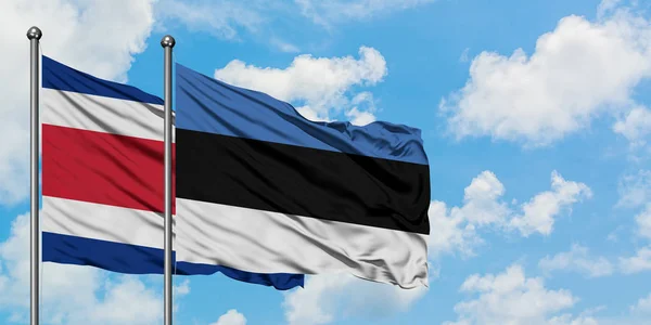 Costa Rica ed Estonia sventolano insieme la bandiera contro il bianco cielo blu nuvoloso. Concetto di diplomazia, relazioni internazionali . — Foto Stock