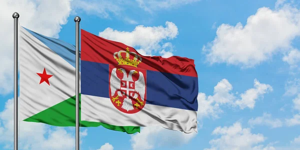 Bandera de Djibouti y Serbia ondeando en el viento contra el cielo azul nublado blanco juntos. Concepto diplomático, relaciones internacionales . — Foto de Stock