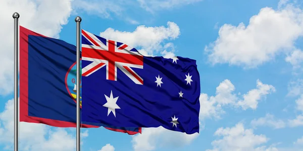 关岛和澳大利亚国旗在风中飘扬，与白云蓝天相一起。外交概念、国际关系. — 图库照片