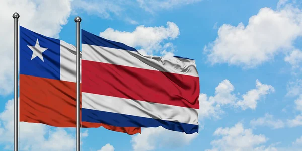 Şili ve Kosta Rika bayrağı birlikte beyaz bulutlu mavi gökyüzüne karşı rüzgarda sallayarak. Diplomasi kavramı, uluslararası ilişkiler. — Stok fotoğraf
