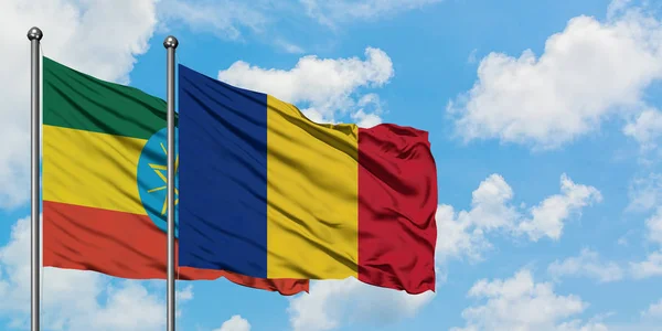 Bandera de Etiopía y Rumanía ondeando en el viento contra el cielo azul nublado blanco juntos. Concepto diplomático, relaciones internacionales . — Foto de Stock