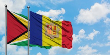 Guyana ve Andorra bayrağı birlikte beyaz bulutlu mavi gökyüzüne karşı rüzgarda sallayarak. Diplomasi kavramı, uluslararası ilişkiler.