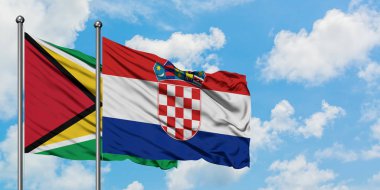 Guyana ve Hırvatistan bayrağı birlikte beyaz bulutlu mavi gökyüzüne karşı rüzgarda sallayarak. Diplomasi kavramı, uluslararası ilişkiler.