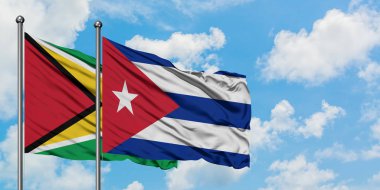 Guyana ve Küba bayrağı birlikte beyaz bulutlu mavi gökyüzüne karşı rüzgarda sallayarak. Diplomasi kavramı, uluslararası ilişkiler.