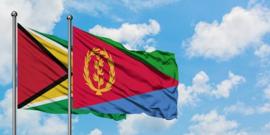Guyana ve Eritre bayrağı birlikte beyaz bulutlu mavi gökyüzüne karşı rüzgarda sallayarak. Diplomasi kavramı, uluslararası ilişkiler.