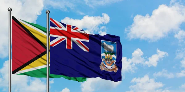 가이아나와 포클랜드 제도 깃발이 하얀 흐린 푸른 하늘을 배경으로 바람에 흔들리고 있습니다. 외교 개념, 국제 관계. — 스톡 사진