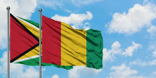 Guyana and Guinea flag waving in the wind against white cloudy blue sky together. Diplomacy concept, international relations. — Stock Photo, Image