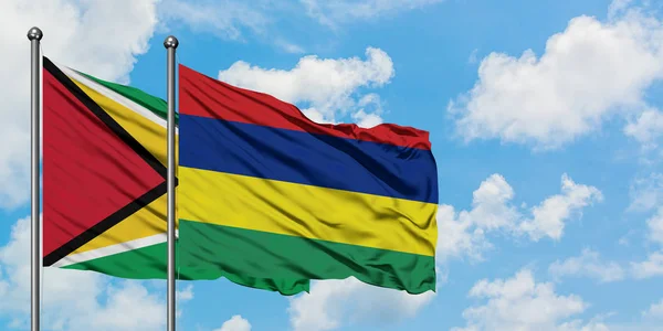 Guyana and Mauritius flag waving in the wind against white cloudy blue sky together. Diplomacy concept, international relations. — Stock Photo, Image