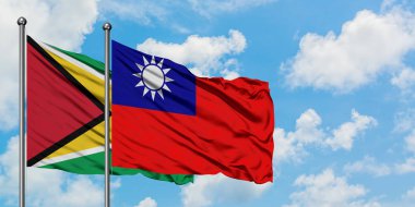 Guyana ve Tayvan bayrağı birlikte beyaz bulutlu mavi gökyüzüne karşı rüzgarda sallayarak. Diplomasi kavramı, uluslararası ilişkiler.