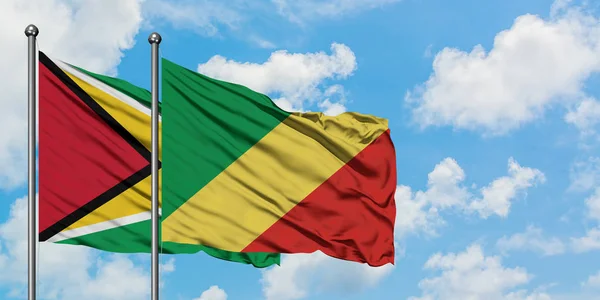 Guyana e Repubblica del Congo sventolano insieme la bandiera contro il bianco cielo azzurro nuvoloso. Concetto di diplomazia, relazioni internazionali . — Foto Stock