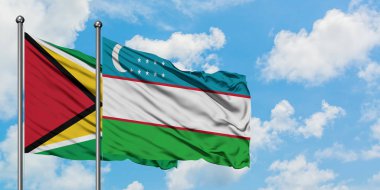 Guyana ve Özbekistan bayrağı birlikte beyaz bulutlu mavi gökyüzüne karşı rüzgarsal sallayarak. Diplomasi kavramı, uluslararası ilişkiler.