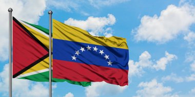Guyana ve Venezuela bayrağı birlikte beyaz bulutlu mavi gökyüzüne karşı rüzgarda sallayarak. Diplomasi kavramı, uluslararası ilişkiler.