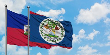 Haiti ve Belize bayrağı birlikte beyaz bulutlu mavi gökyüzüne karşı rüzgarda sallayarak. Diplomasi kavramı, uluslararası ilişkiler.