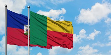 Haiti ve Benin bayrağı birlikte beyaz bulutlu mavi gökyüzüne karşı rüzgarda sallayarak. Diplomasi kavramı, uluslararası ilişkiler.