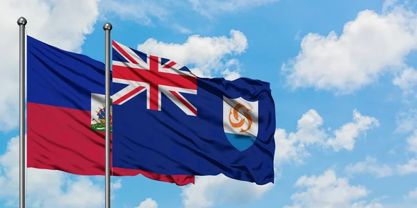 Haití y la bandera de Anguila ondeando en el viento contra el cielo azul nublado blanco juntos. Concepto diplomático, relaciones internacionales . —  Fotos de Stock