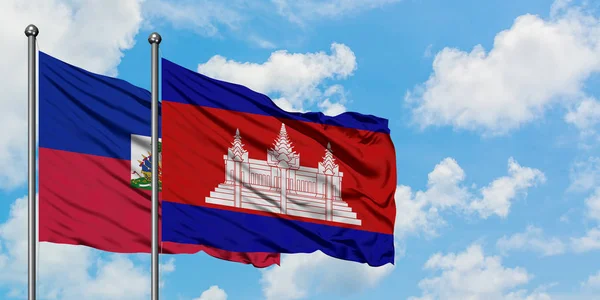 Haiti och Kambodja flagga viftande i vinden mot vit grumlig blå himmel tillsammans. Diplomatisk koncept, internationella relationer. — Stockfoto