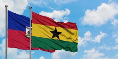 Haiti ve Gana bayrağı birlikte beyaz bulutlu mavi gökyüzüne karşı rüzgarda sallayarak. Diplomasi kavramı, uluslararası ilişkiler.