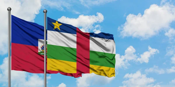 Bandera de Haití y República Centroafricana ondeando en el viento contra el cielo azul nublado blanco juntos. Concepto diplomático, relaciones internacionales . — Foto de Stock