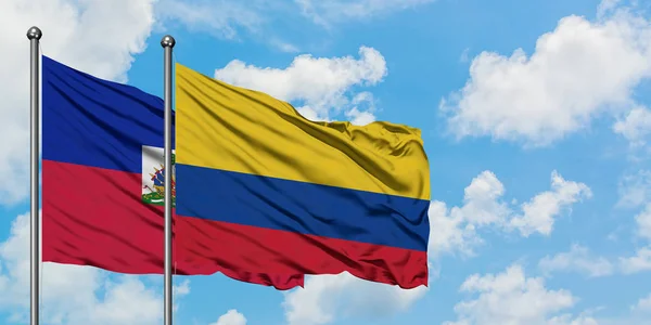 Haiti and Colombia flag waving in the wind against white cloudy blue sky together. Diplomacy concept, international relations. — Stock Photo, Image